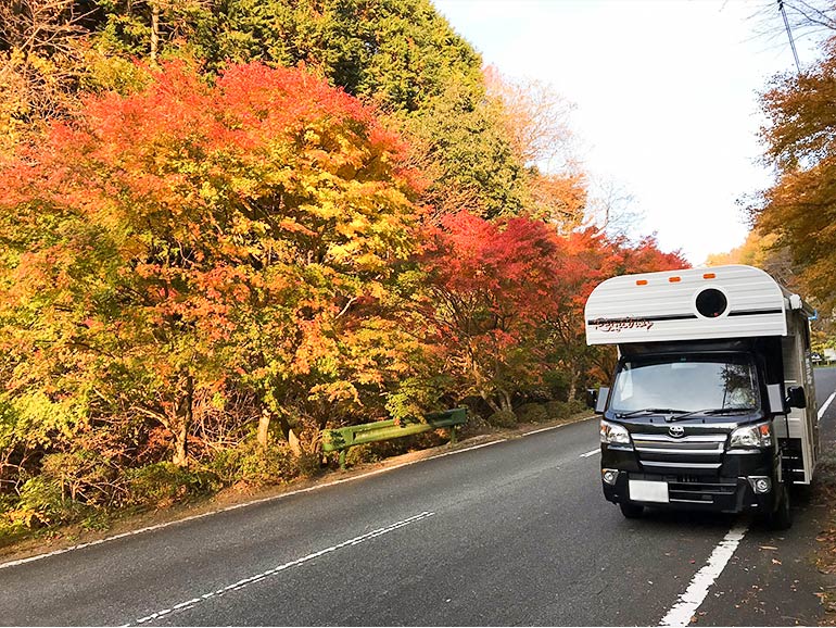 紅葉の中停まっているキャンピングカー