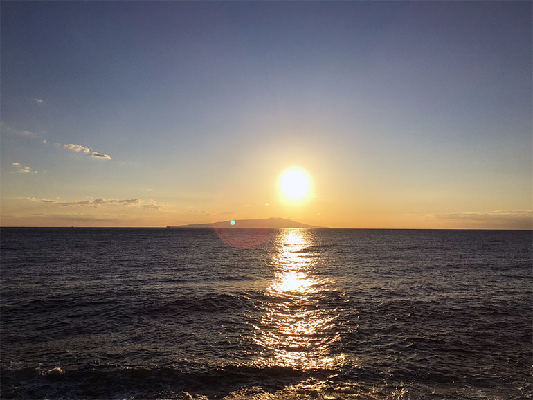 海に夕日が沈んでいく様子