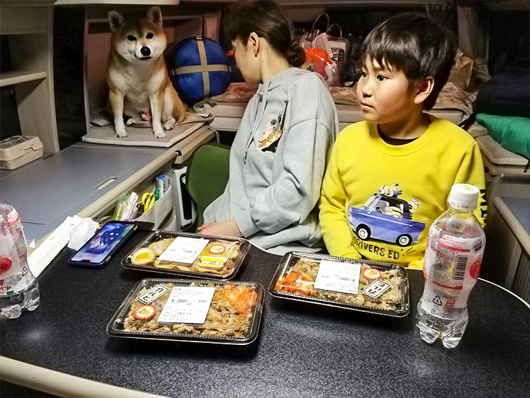 車内でお弁当を食べる家族