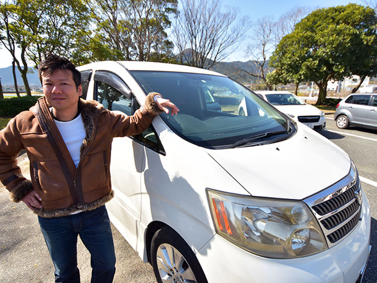 愛車の前に立つ男性