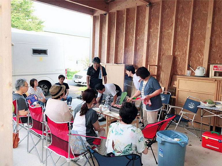 ガレージで仲間とBBQをしている風景