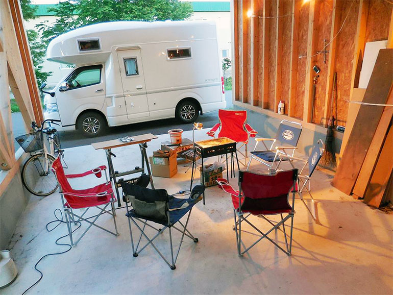 ガレージに用意されたBBQセットと横に停められたキャンピングカー