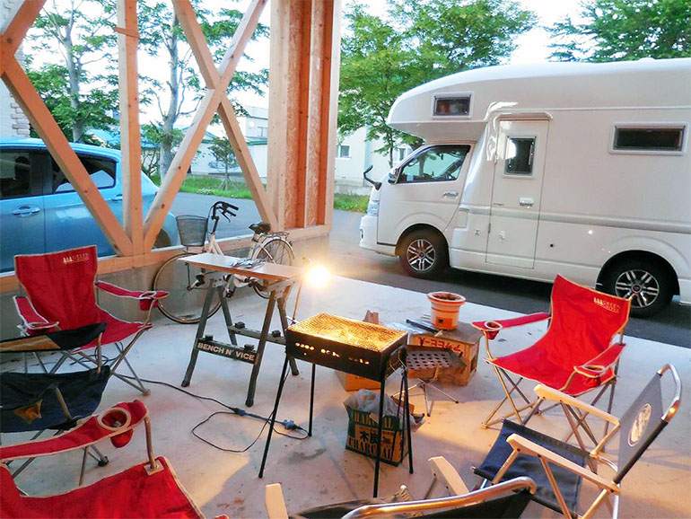 ガレージに用意されたBBQセットと横に停められたキャンピングカー